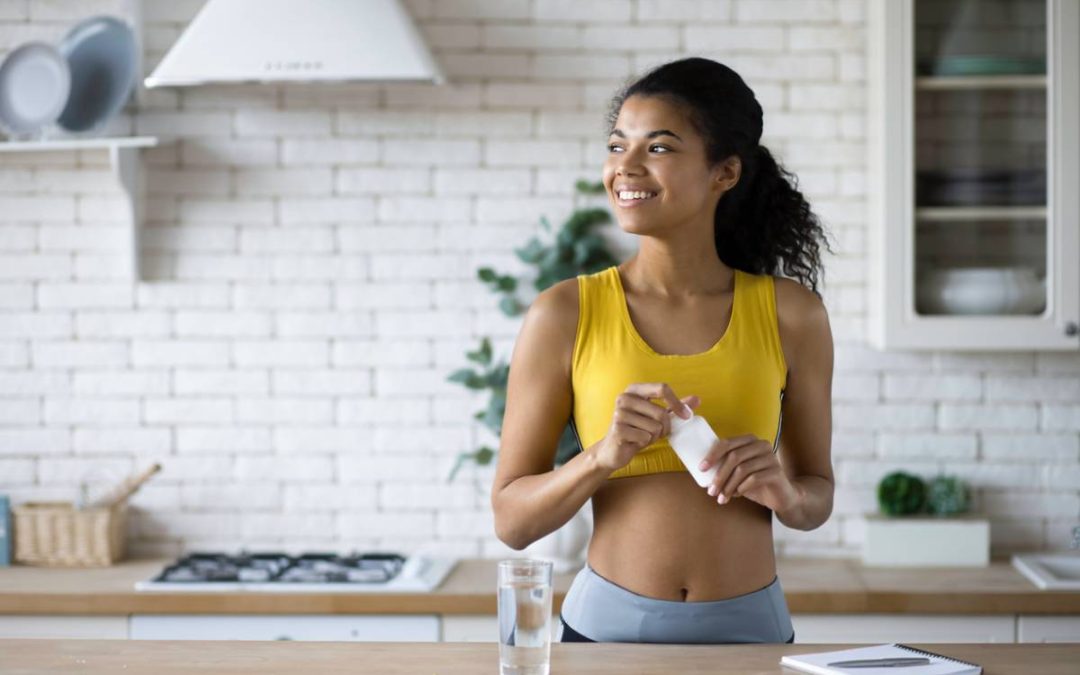 woman smiling and taking some dietary supplements on a good day